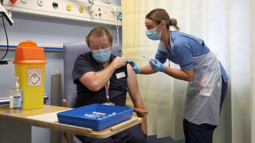 Deputy charge nurse Katie McIntosh administers the first of two Pfizer/BioNTech Covid-19 vaccine jabs to Clinical Lead of Outpatient Theatres, Andrew Mencnarowski at the Western General Hospital