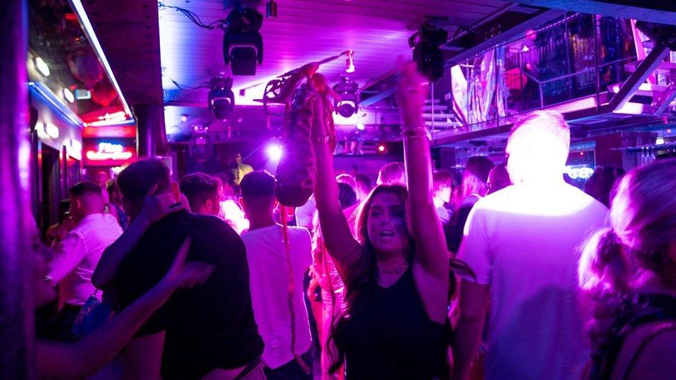 A woman dances on the first night clubs reopen in England