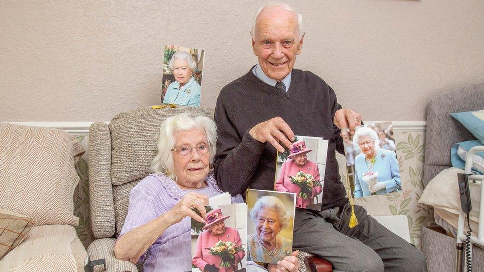 Ivy and John Winn hold pictures of the Queen