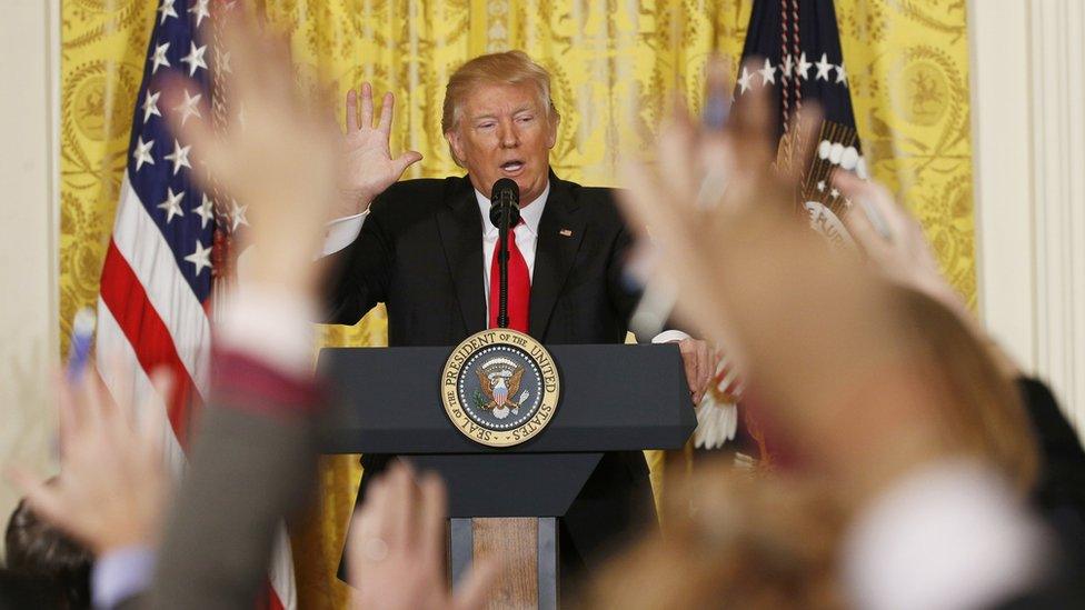 Donald Trump faces a sea of reporters' hands.