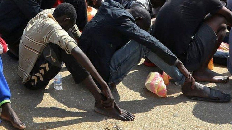 Migrants sit in rows