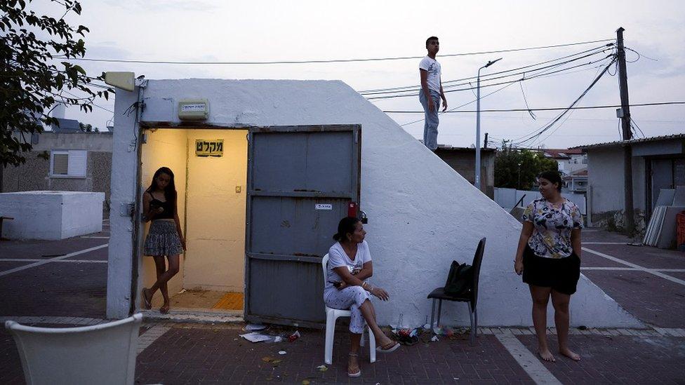 Israelis hang out around the entrance to a bomb shelter as rockets from Gaza are launched towards Israel in Ashkelon