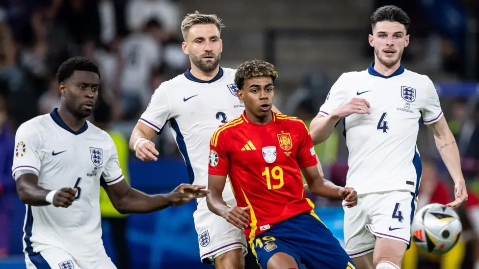 Spain's Lamine Yamal is surrounded by England players Declan Rice, Luke Shaw and Marc Guehi