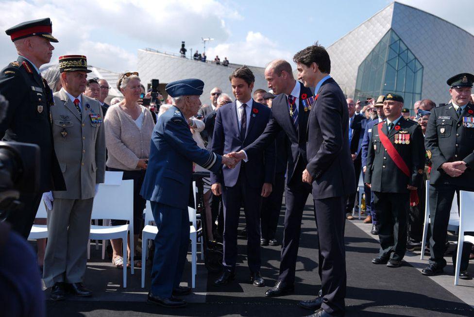 Prince William, Prince of Wales (2nd R) meets Richard Rohmer, 100, one of the most decorated Canadian veterans, accompanied by the Prime Minister of France Gabriel Attal (C) and Canadian Prime Minister Justin Trudeau (R) during the Government of Canada ceremony to mark the 80th anniversary of D-Day, at Juno Beach on June 6, 2024 in Courseulles-sur-Mer, France. 