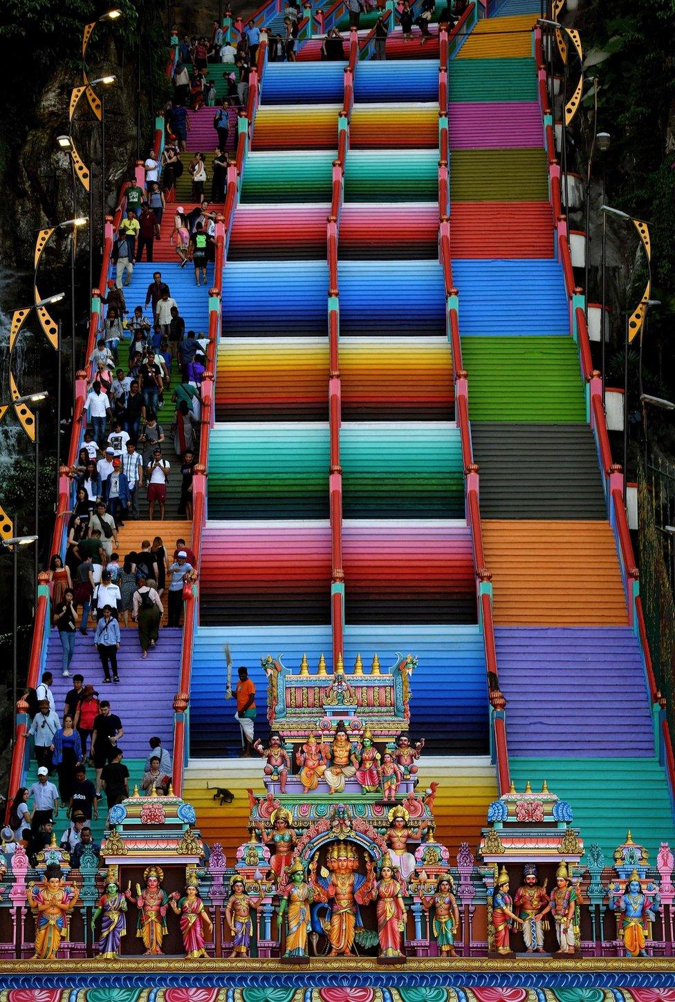 Visitors walk on the colourful stairs at Malaysia's Batu Caves