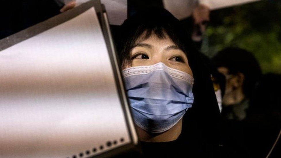 A protester holds a blank piece of paper