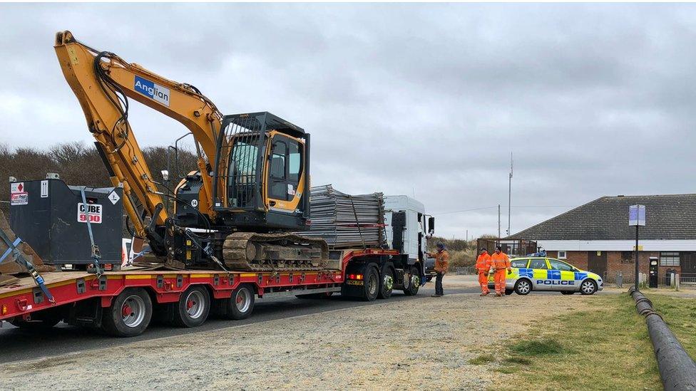 Digger on flat bed lorry