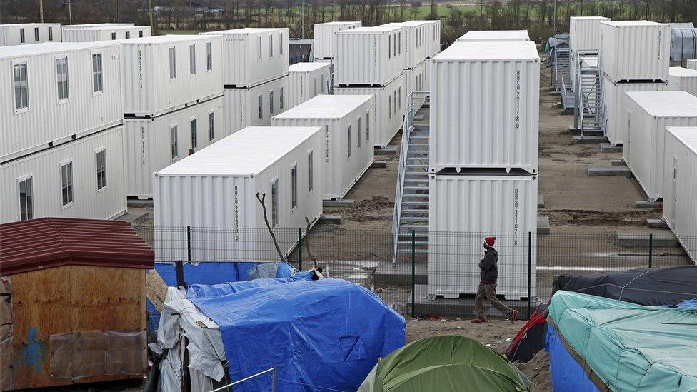 Containers are put into place to house several hundred migrants