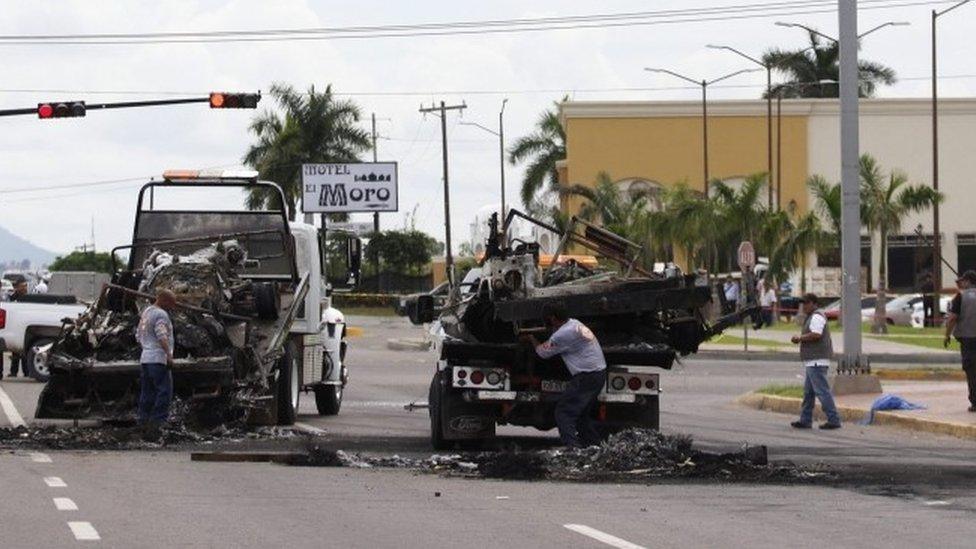 Officials remove burned vehicles away from a crime scene after an ambush perpetrated by alleged members of an organised crime syndicate in Culiacan, Sinaloa, Mexico (30 September 2016)