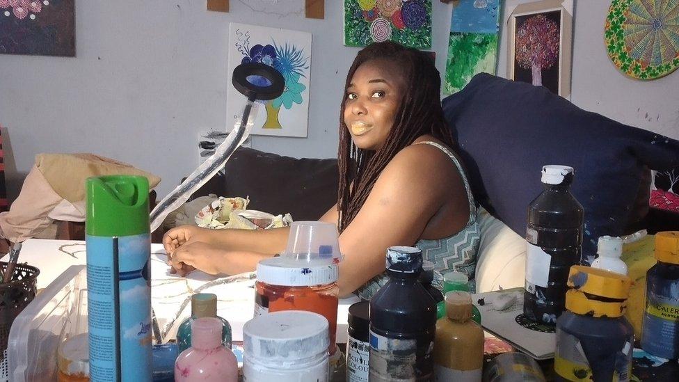 Ijeoma Ogwuegbu surrounded by paints