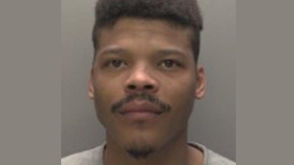 Police mugshot of Tyevon Bean. He has dark hair, a moustache and a goatee beard.