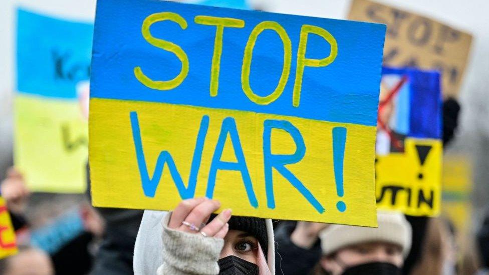 Person holding up 'Stop War' sign