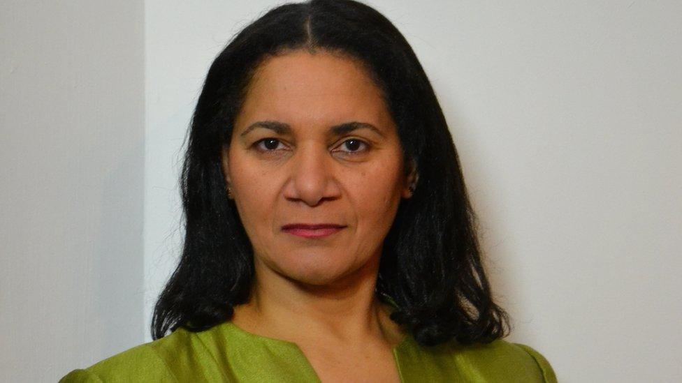 Headshot of Anne Giwa-Amu , wearing a lime green jacket