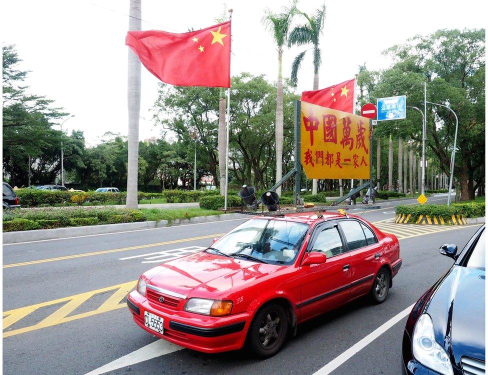 A member of a pro-unification group drives a red car displaying China's national flags and a sign saying "Long Live China. We Are One Family", to show support for the up-coming meeting between Taiwan"s President Ma Ying-jeou and Chinese President Xi Jinping, in Taipei, Taiwan, 4 November 2015