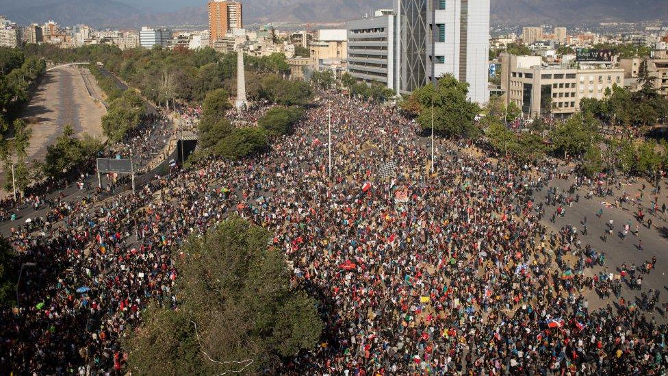 People gather for an anti-government protest in Santiago, Chile, Friday, Nov. 1, 2019. Groups of Chileans continued to demonstrate as government and opposition leaders debate the response to nearly two weeks of protests that have paralyzed much of the capital and forced the cancellation of two major international summits.