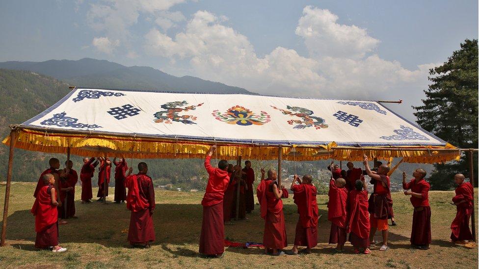 Monks put up a marquee in preparation for the UK royals' visit