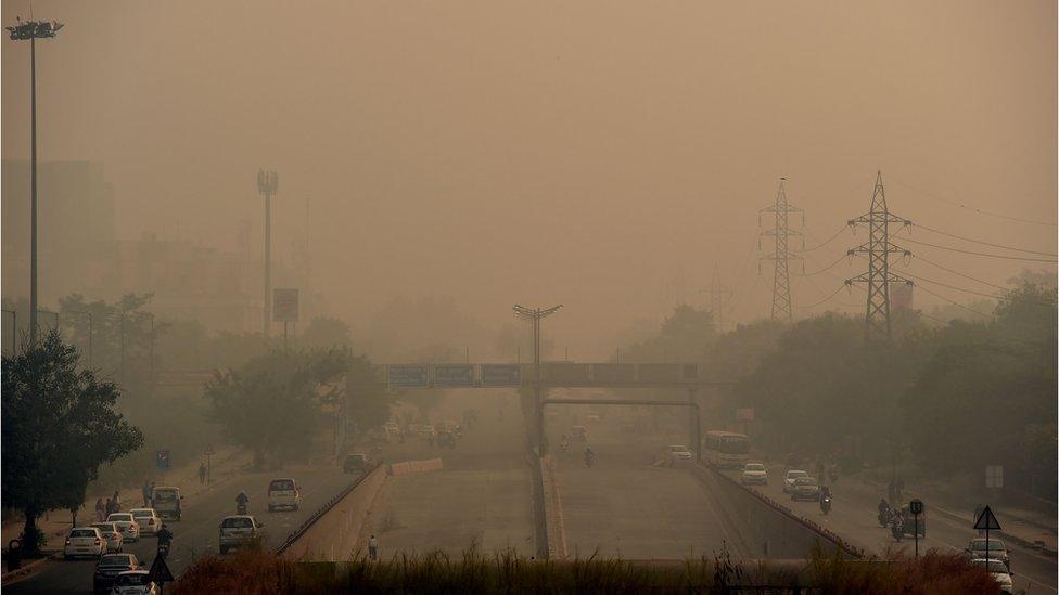 Indian commuters drive through smog in New Delhi on October 31, 2016, the day after the Diwali festival