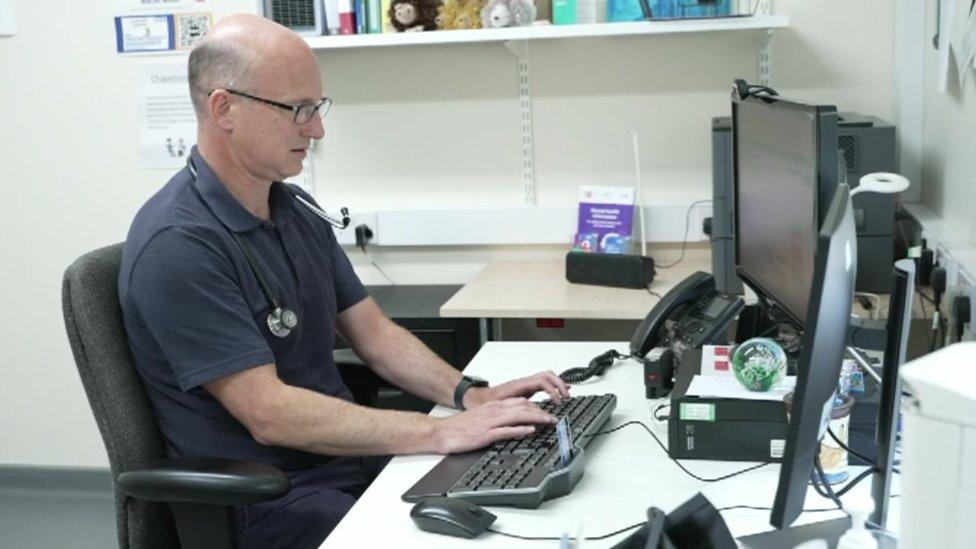 Dr Jack Jacobs sitting at his desk in the surgery