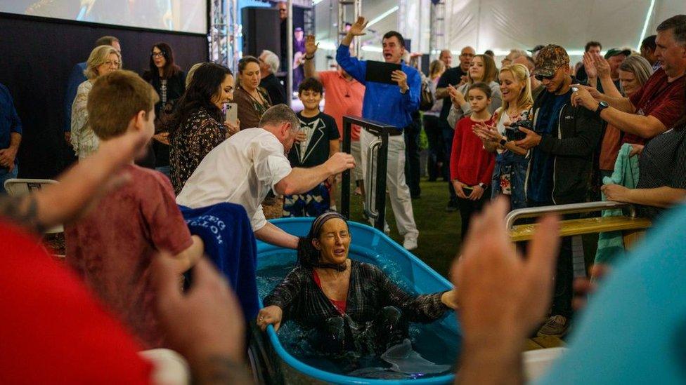 Pastor Greg Locke administers a baptism at his church