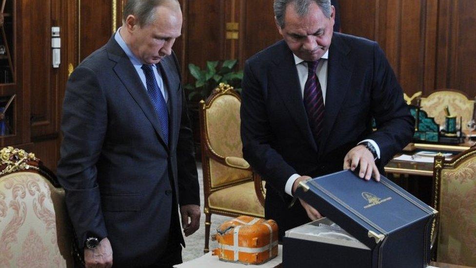 Russian Defence Minister Sergei Shoigu (right) shows President Vladimir Putin a flight recorder from the downed Su-24 bomber