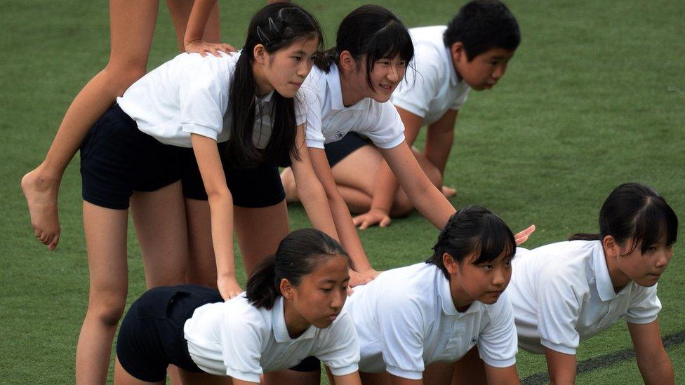 Japanese children, including Princess Aiko, build a human pyramid