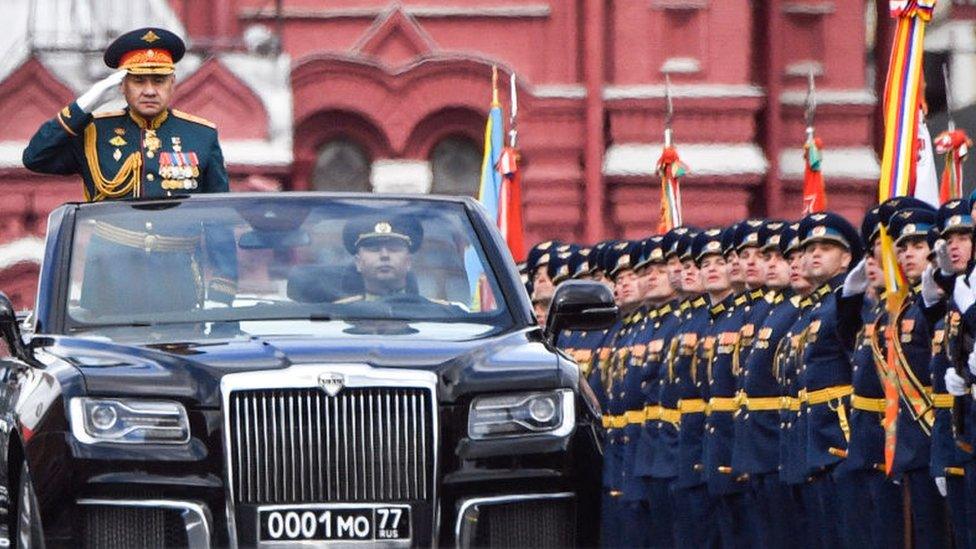 Russian Defence Minister Sergei Shoigu salutes to soldiers as he is driven along Red Square during the Victory Day military parade in central Moscow