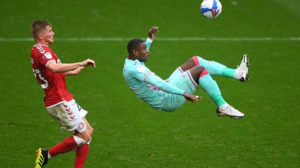 Swansea's Marc Guehi tries an overhead kick as Taylor Moore watches on