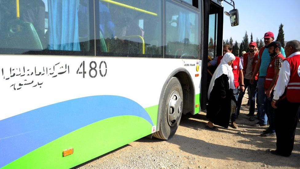 A woman evacuated from the besieged town of Darayya arrives at a government district