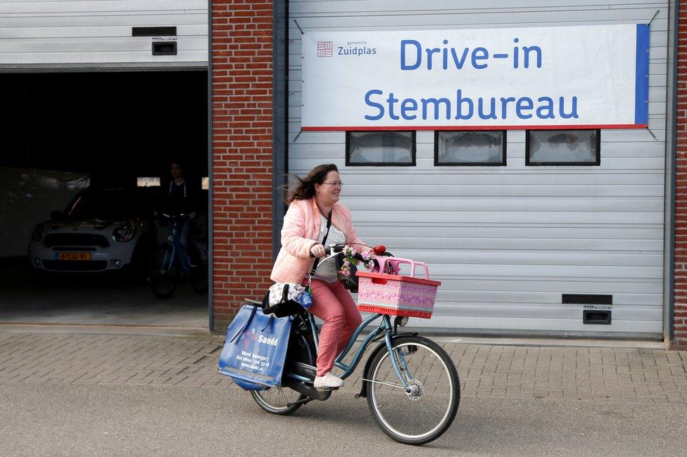 A cyclist casts a ballot in a drive-in polling station during the Dutch general election in Zuidplas, Netherlands, 15 March