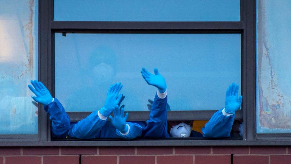 Staff wave out of the Royal Gwent Hospital window