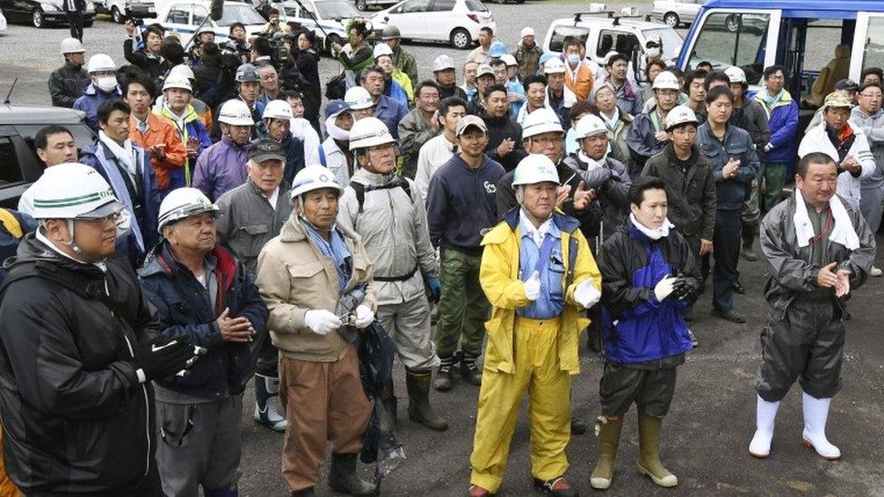 Rescuers celebrate after a news that a missing boy was found, in Nanae town, on Hokkaido, the northernmost of Japan"s four main islands Friday, June 3, 2016.