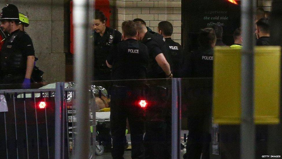 Police wheel away a man on a stretcher after the blast