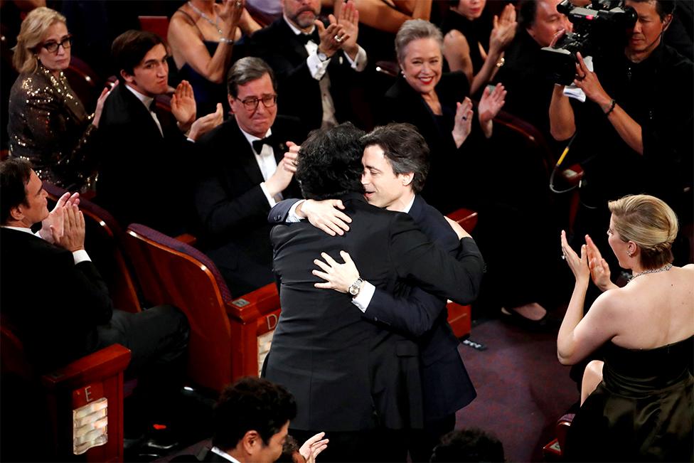 Director Bong Joon-ho receives a hug from Noah Baumbach