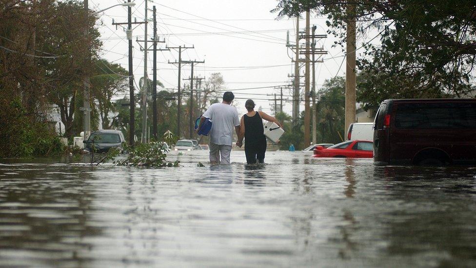 A couple wade through a flooded Key West street in aftermath of Wilma