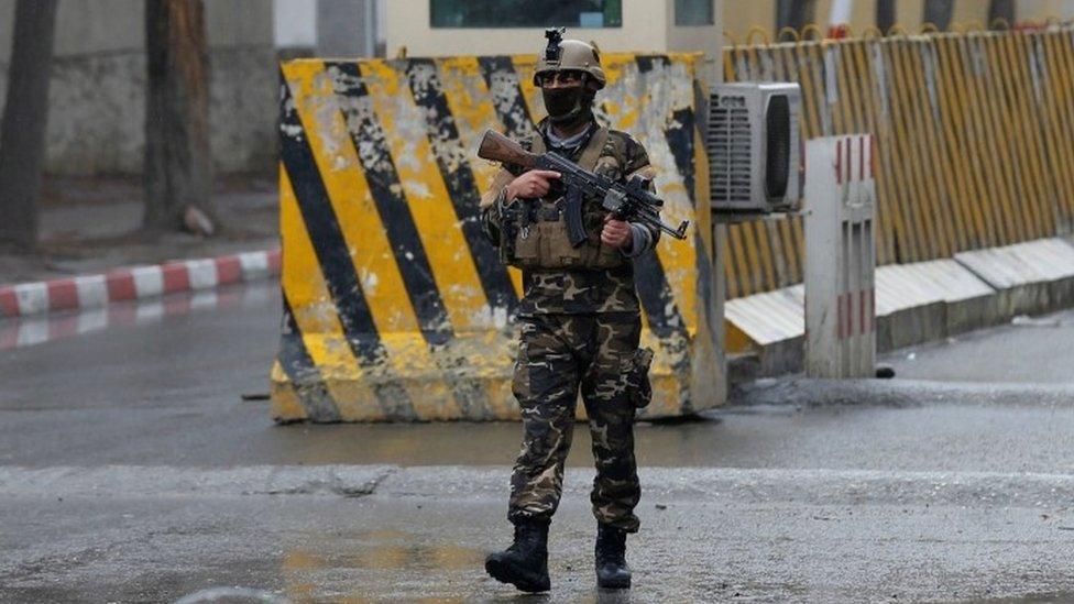 An Afghan security officer holds a gun in the capital Kabul