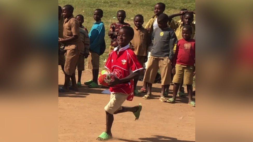 A young boy in Rwanda playing rugby