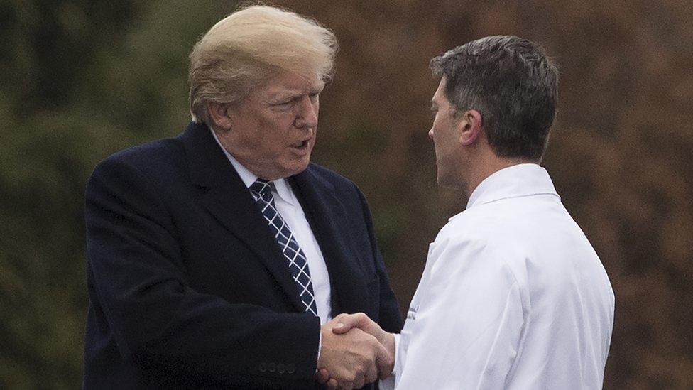 Donald Trump shakes Ronny Jackson's hand.