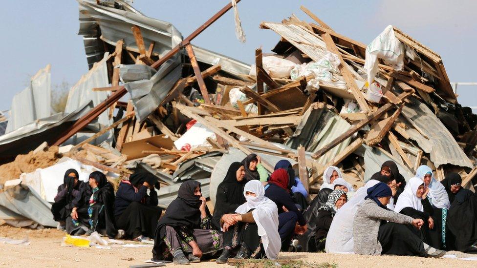 Israeli Arab women sit next to demolished homes in Umm al-Hiran (18 January 2017)