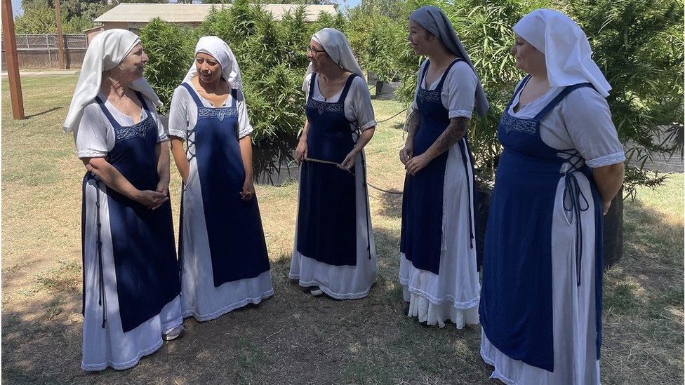 Sisters of the Valley members talk in front of cannabis plants