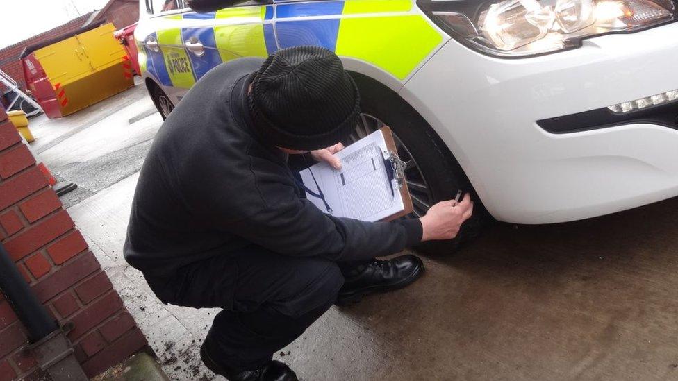 Volunteer checks police car