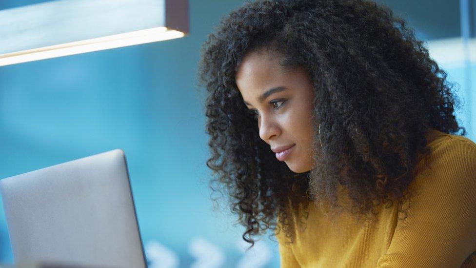 Woman looking at laptop in office