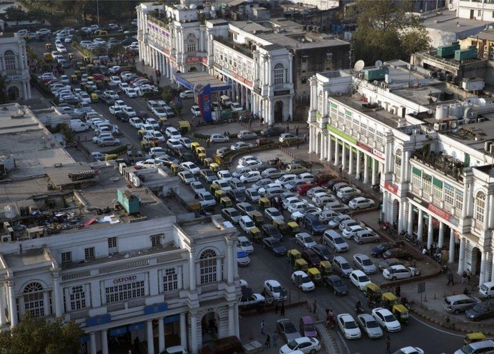 Cars and autorickshaws move through the central Connaught Place area in New Delhi, India, Thursday, Dec. 24, 2015.