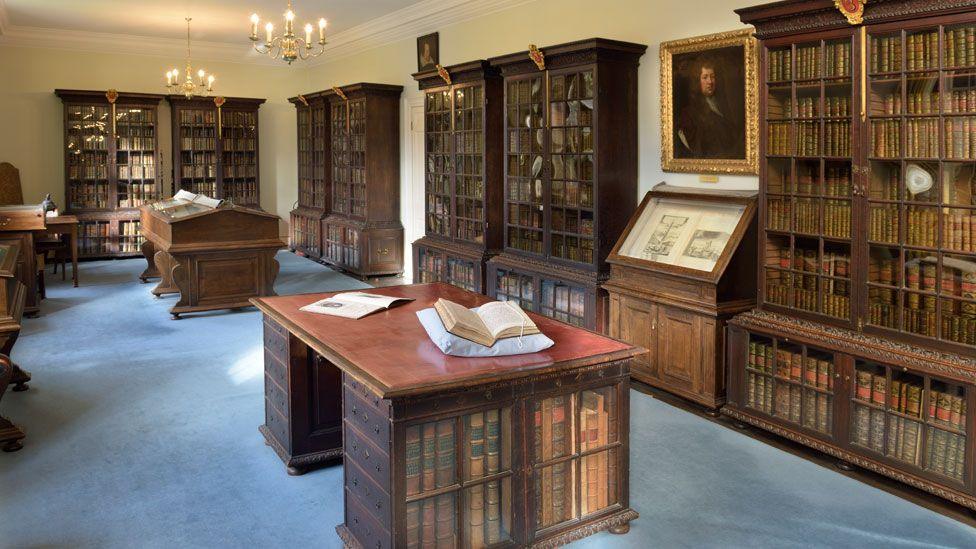 Interior of the Wren Library, Magdalene College, Cambridge, showing Samuel Pepys dark wooden and glazed shelves filled with his book collection