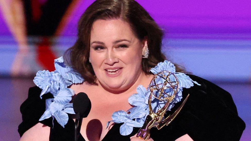 Jessica Gunning holding her Emmy on stage