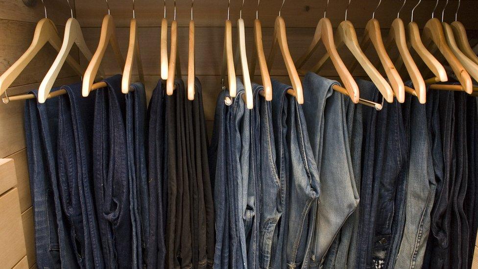 Rows of jeans in a wardrobe