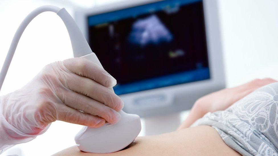 Pregnant woman getting ultrasound from doctor