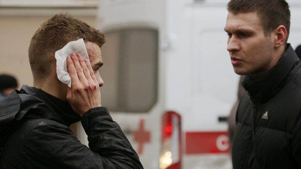 An injured commuter outside Sennaya Ploshchad metro station following explosions in St Petersburg, Russia, 3 April 2017