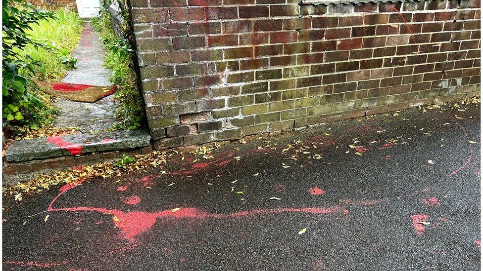 Graffiti in red paint on the wall