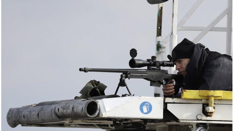 A sniper aims his weapon securing the area as President Barack Obama arrives at the Athens International Airport Eleftherios Venizelos on Tuesday, Nov. 15 2016