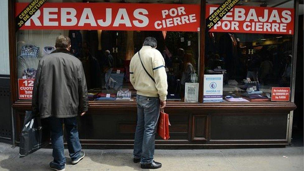 Men look through a shop window in Buenos Aires on 13 October, 2015